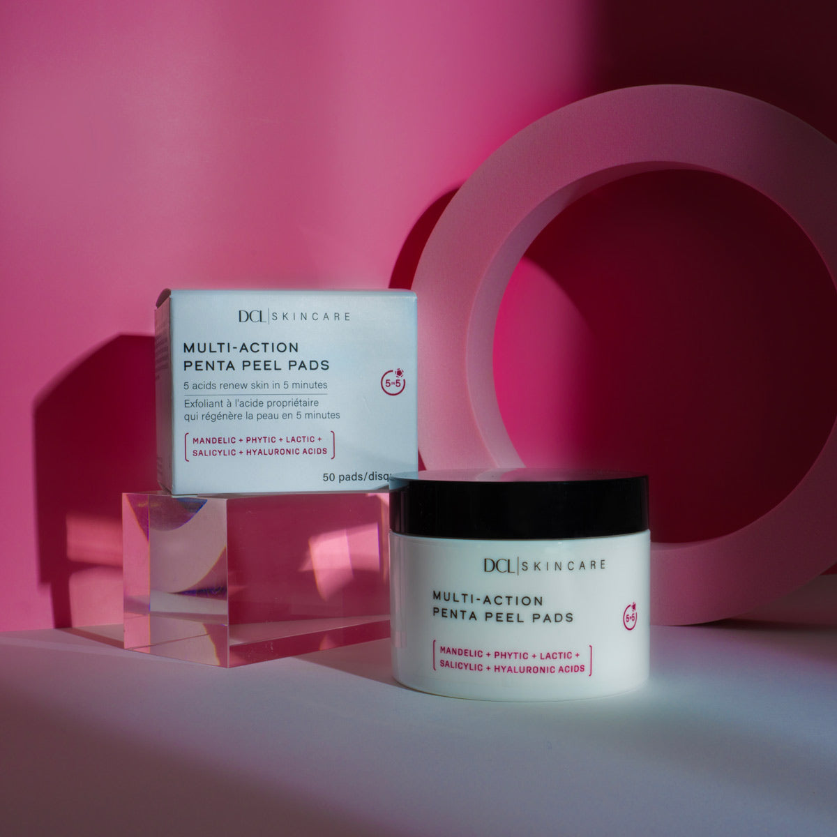 Multi-Action Penta Peel pads jar and carton on glass cube with pink background and shadows